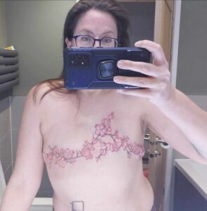 Claire showing off her breast tattoos