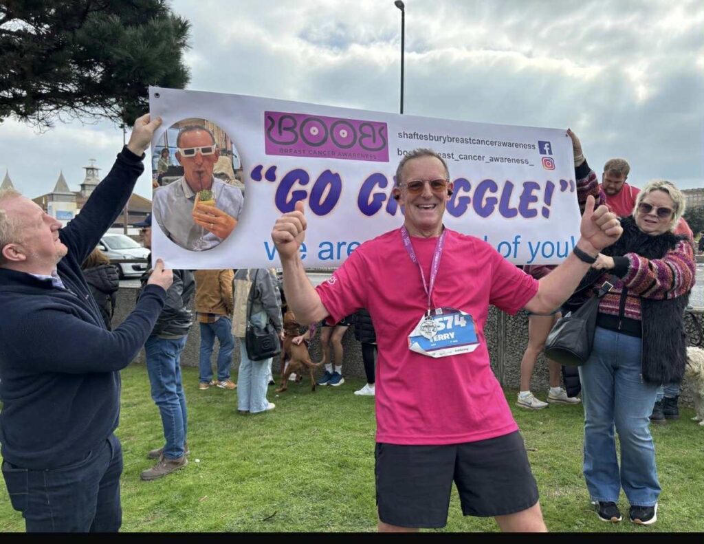 Happy man standing in front of a huge sign