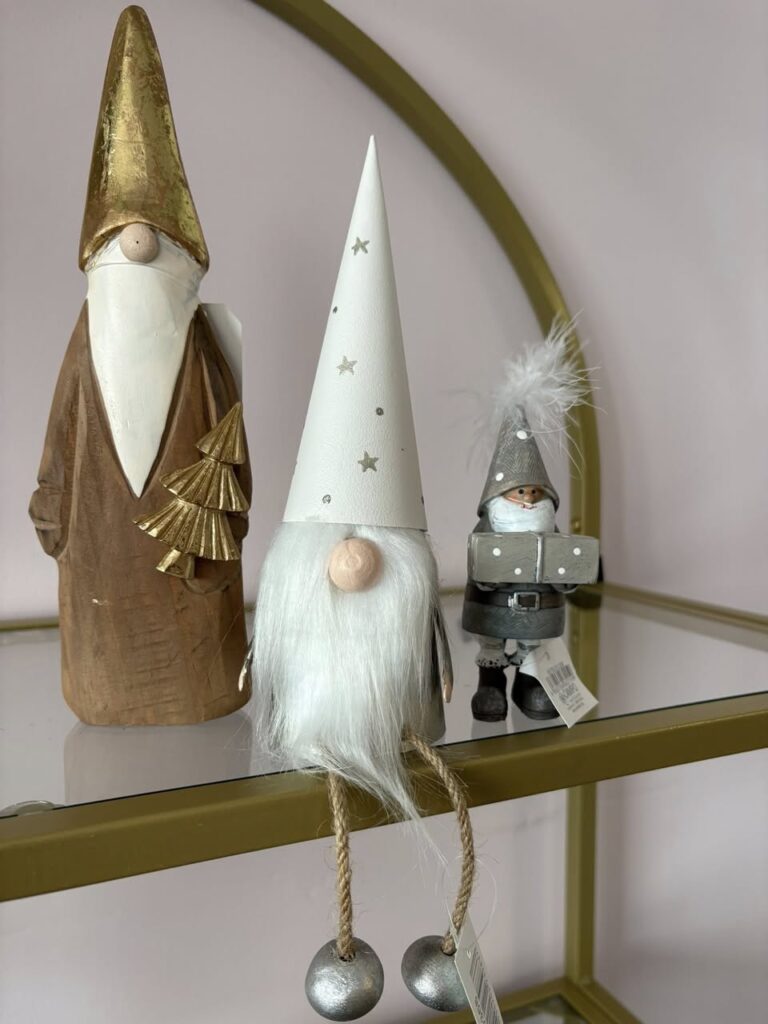 Two gone toys (little people with big noses and white beards), one sitting, with a white hat and yellow stars. Another standing in gold hat and robes.